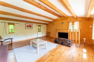 a living room with wooden ceilings and a fireplace at La Petite Palasse in Le Thor