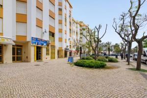 a cobblestone street in front of a building at Apartamento Sun7set in Quarteira