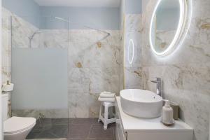 a white bathroom with a sink and a mirror at Apartamento Sun7set in Quarteira +14 photos