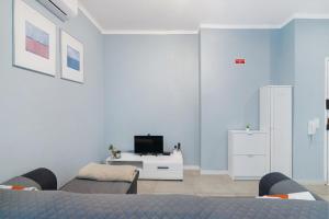 a white room with a bed and a tv in it at Apartamento Sun7set in Quarteira