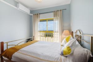 a bedroom with a bed and a large window at Apartamento Sun7set in Quarteira