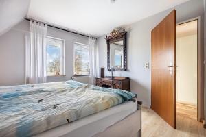 a bedroom with a bed and a mirror at Ferienhaus Kapitänsstuv in Kaiser Wilhelm Koog