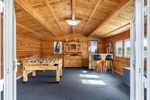 a game room with a pool table and a wooden ceiling at Ferienhaus Kapitänsstuv in Kaiser Wilhelm Koog
