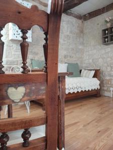 a bedroom with a wooden bed in a stone wall at La Petite Authentique in Gaillac-dʼAveyron