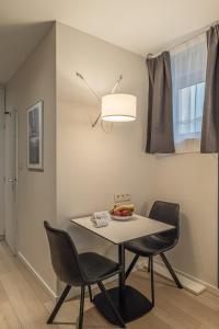 a dining room with a table and two chairs at Five Resort Cholet Centre in Cholet