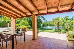 an outdoor patio with a wooden pergola at Sontuiri den Jaume in Pollença