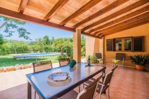 a patio with a table and chairs and a pool at Sontuiri den Jaume in Pollença