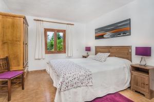 a bedroom with a bed and a chair and a window at Sontuiri den Jaume in Pollença +9 photos