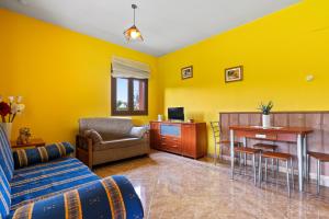 a yellow living room with a couch and a table at Apartamentos Les Cuartes in Cangas de Onís