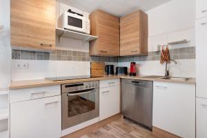 a kitchen with white cabinets and stainless steel appliances at Wanderpfoten Ostsee Ferienhaus in Tribsees