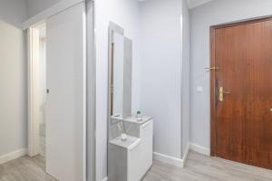 a bathroom with a mirror and a wooden door at Grey House in Huelva +14 photos