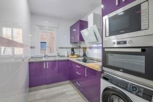 a kitchen with purple cabinets and a microwave at Grey House in Huelva