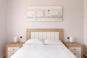 a bedroom with a white bed with two night stands at Golf And Sun in Los Alcázares +17 photos
