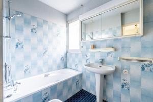 a bathroom with a sink and a tub and a toilet at Cap sur la détente - 128 in Pornic +15 photos