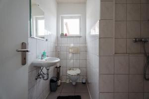 a white bathroom with a sink and a toilet at Apartment 19 in Schutterwald +17 photos