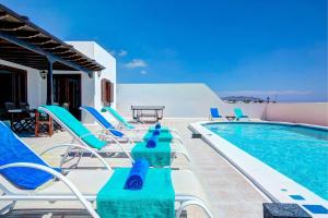 a group of chairs and a swimming pool at Casa Paula in Yaiza