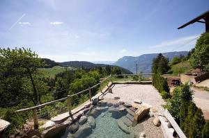 a hot tub in a garden with mountains in the background at Eggerhof Fernblick in Verano +13 photos