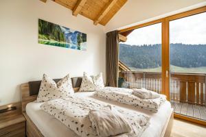 two beds in a bedroom with a large window at Eggerhof Fernblick in Verano