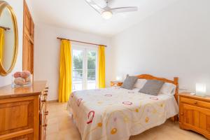 a bedroom with a bed and a window with yellow curtains at Apartamento Minerva in Alcudia