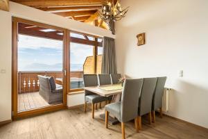 a dining room with a table and chairs and a balcony at Eggerhof Fernblick in Verano