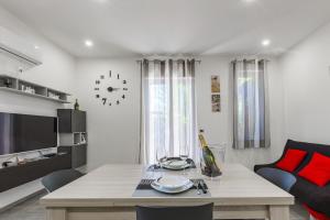 a living room with a table and a couch at Casa Gioiosa Holidays in Gioiosa Marea
