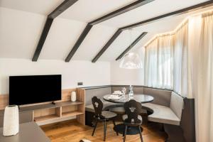 a living room with a table and a tv at Residence Skutial App Schlern in Castelrotto