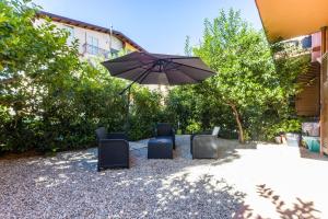 a group of chairs and an umbrella in a yard at Casa Gioiosa Holidays in Gioiosa Marea