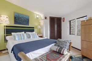 a bedroom with a large bed and a chair at Los Jazmines in Agaete +28 photos