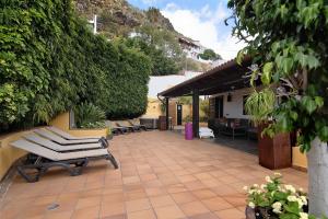a patio with two lounge chairs and a building at Los Jazmines in Agaete