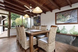 a dining room with a table and wicker chairs at Los Jazmines in Agaete
