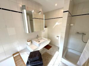 a white bathroom with a sink and a shower at Lüttje Reethuus in Südbrookmerland +31 photos