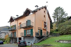 a building with balconies and a car parked in front of it at La Casetta Chiesa Valmalenco in Chiesa in Valmalenco
