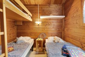 two beds in a room with wooden walls at Chalet confort 20 in Saint-Gervais