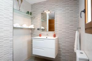 a white bathroom with a sink and a mirror at Reina's in Vejer de la Frontera +13 photos