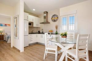 a kitchen with a glass table and white chairs at Casa Orilla Sur B in El Palmar