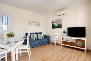 a living room with a blue couch and a tv at Casa Orilla Sur B in El Palmar