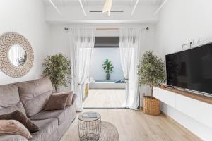 a living room with a couch and a flat screen tv at Casa Catral Alfalfar 12 in Catral