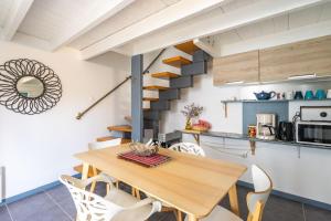 a kitchen and dining room with a wooden table and chairs at Gite Du Porche Bis in Chaillevette +12 photos