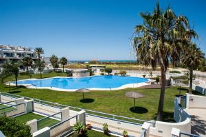 Una vista de una piscina desde un balcón de un resort. en BLUE FIN Tarifa, en Tarifa