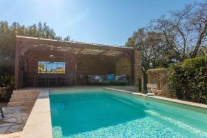 a swimming pool in a backyard with a pavilion at La Petite Maison Jaune in Grimaud