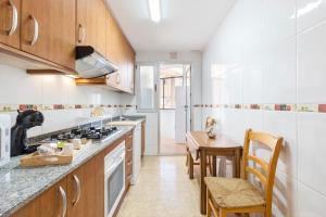 a kitchen with wooden cabinets and a table and chairs at Vivienda maiva in Alhama de Murcia