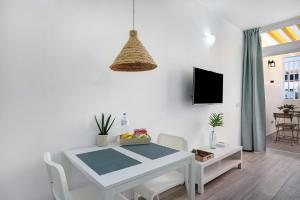 a white table and chairs in a room with a tv at Estudio Sagrario in Arona