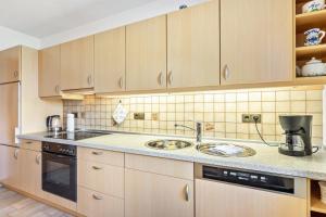 a kitchen with wooden cabinets and a sink at Ferienwohnung Tannenberg in Diemelstadt 