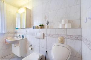 a white bathroom with a toilet and a sink at Ferienwohnung Tannenberg in Diemelstadt  +26 photos