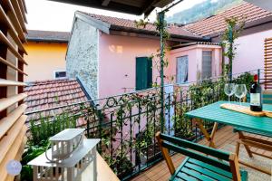 a balcony with a table and chairs and a wine bottle at Nido Blu - Vista Lago in Belgirate