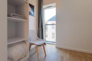 a room with a chair and a window at Regard Marin - Appartement 4 pers in Le Palais