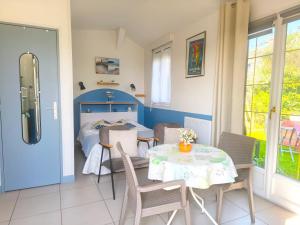 a room with a table and chairs and a bed at Petit Gîte Douillet L'abri Côtier in Saint-Léonard