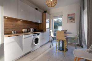 a kitchen with a washing machine and a table at Regard Marin - Appartement 4 pers in Le Palais