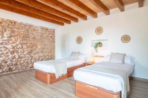 two beds in a room with a stone wall at Son Guillem in Son Sardina +28 photos