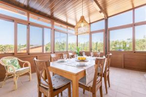 a dining room with a table and chairs and windows at Son Guillem in Son Sardina